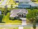 Aerial view of a home with well-maintained landscaping and a brick driveway in a suburban neighborhood at 5509 Meadow Hill Loop, Lady Lake, FL 32159