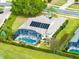 An aerial view displays the house with its screened-in pool and solar panels, set in a landscaped yard at 5509 Meadow Hill Loop, Lady Lake, FL 32159