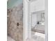 Modern shower with floor-to-ceiling tile and a peek into the bedroom of this stylish home at 5509 Meadow Hill Loop, Lady Lake, FL 32159