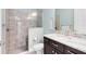 Bathroom showcasing tiled shower, a marble countertop vanity with dark cabinets, and soft lighting at 5509 Meadow Hill Loop, Lady Lake, FL 32159