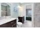 Bathroom with granite countertop vanity, tile floors, and shower visible from the door into the bedroom at 5509 Meadow Hill Loop, Lady Lake, FL 32159
