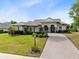 Charming single-story home with a well-manicured lawn, brick driveway, and inviting front entrance at 5509 Meadow Hill Loop, Lady Lake, FL 32159