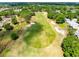 Scenic aerial view of a lush green golf course surrounded by mature trees and sand traps at 5509 Meadow Hill Loop, Lady Lake, FL 32159