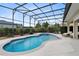 Enclosed in-ground pool with an adjacent spa and lounge chairs, surrounded by a screened enclosure at 5509 Meadow Hill Loop, Lady Lake, FL 32159
