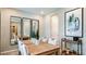 Elegant dining room with a long wooden table, modern mirrors, and stylish decor at 557 Moon Shell Cir, New Smyrna Beach, FL 32168