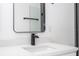 Modern bathroom with a black faucet, mirror and white countertop creating a clean aesthetic at 6872 Sw 132Nd Pl, Ocala, FL 34473