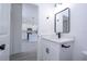 Modern bathroom features a vanity with a black faucet, a rectangular mirror, and white cabinets at 6872 Sw 132Nd Pl, Ocala, FL 34473