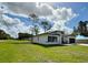 Stylish single-story house with dark shutters, a manicured lawn, and a lengthy driveway leading to the garage at 6872 Sw 132Nd Pl, Ocala, FL 34473