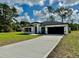 Attractive single-Gathering home with a well-kept green lawn, an extended driveway, and black trim at 6872 Sw 132Nd Pl, Ocala, FL 34473