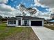 Charming single-story house with a neatly manicured lawn, a long driveway, and a covered entryway at 6872 Sw 132Nd Pl, Ocala, FL 34473