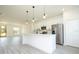 Bright, modern kitchen with white cabinetry, stainless steel appliances, and an island with pendant lighting at 6872 Sw 132Nd Pl, Ocala, FL 34473