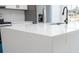 Close-up of a quartz countertop island in the kitchen with a stainless steel sink and black fixtures at 6872 Sw 132Nd Pl, Ocala, FL 34473