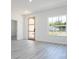 Bright living room features luxury vinyl plank floors, a modern wood-trimmed door, and ample natural light at 6872 Sw 132Nd Pl, Ocala, FL 34473