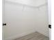 Bright walk-in closet featuring white walls, wire shelving, and light wood-look flooring at 6872 Sw 132Nd Pl, Ocala, FL 34473