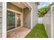 View of the back patio, artificial turf, and open sliding glass doors to the home's interior at 730 Cordova Dr, Orlando, FL 32804