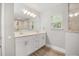Bathroom featuring double vanity with large mirror and window, along with a tiled shower/tub at 730 Cordova Dr, Orlando, FL 32804