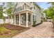 Beautiful two-story home with a welcoming front porch, black shutters, and a brick-paved driveway at 730 Cordova Dr, Orlando, FL 32804
