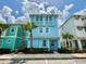 Charming two-story blue home with colorful details, lush landscaping, and a sidewalk leading to the front door at 7968 Shaker St, Kissimmee, FL 34747