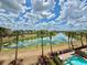 Scenic waterfront view with palm trees, a lake reflecting the cloudy sky, and colorful houses in the background at 7968 Shaker St, Kissimmee, FL 34747