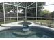Serene pool with a charming water feature and tiled accents, nestled within a screened enclosure at 854 Escabar Dr, Altamonte Springs, FL 32714