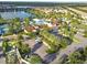 Aerial view of the community clubhouse and pool area with nearby lake, basketball court, and ample parking at 8808 Macapa Dr, Kissimmee, FL 34747