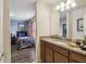 Well-lit bathroom features a granite countertop vanity and a partial view into the adjacent bedroom at 8808 Macapa Dr, Kissimmee, FL 34747