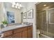 Bathroom featuring a single sink, a granite countertop, wooden cabinets, and a shower with sliding glass doors at 8808 Macapa Dr, Kissimmee, FL 34747