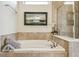 Well-lit bathroom features a soaking tub, glass shower, and neutral tile at 8808 Macapa Dr, Kissimmee, FL 34747