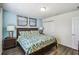 Bedroom with bed, nightstand with lamps, wood floors, closet, and artwork at 8808 Macapa Dr, Kissimmee, FL 34747