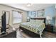 Bedroom features a bed, a nightstand with lamps, wood floors, and natural light at 8808 Macapa Dr, Kissimmee, FL 34747