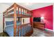 Bedroom featuring a wooden bunk bed with blue bedding, a red accent wall, and wood-look flooring at 8808 Macapa Dr, Kissimmee, FL 34747