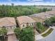 Aerial view of a beige home featuring a brick driveway and walkway and tropical trees at 8808 Macapa Dr, Kissimmee, FL 34747