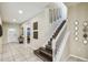 Bright foyer with neutral paint and tile, featuring a staircase and views of the front door at 8808 Macapa Dr, Kissimmee, FL 34747