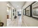Long hallway with neutral tile flooring, leading to the dining area and featuring decorative wall art at 8808 Macapa Dr, Kissimmee, FL 34747