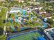 Aerial view of the community lazy river with surrounding palm trees and tropical landscaping, and a nearby basketball court at 8808 Macapa Dr, Kissimmee, FL 34747