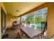 Covered patio with a table, seating, brick tiles and views of the screened-in pool area at 8808 Macapa Dr, Kissimmee, FL 34747