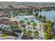 Aerial view of the community pool area with lazy river, splash pad, lounge chairs, and lush landscaping, near the lake at 8808 Macapa Dr, Kissimmee, FL 34747