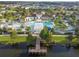 Aerial view of the community pool and clubhouse with a pier extending onto the lake at 8808 Macapa Dr, Kissimmee, FL 34747