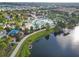 Aerial view of the community pool, clubhouse, playground, pier, and lake in a residential neighborhood at 8808 Macapa Dr, Kissimmee, FL 34747