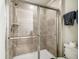 Bathroom featuring a shower with glass doors and beige tiled walls and a handheld shower head at 8808 Macapa Dr, Kissimmee, FL 34747