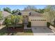Charming front elevation of a one-story home with a two-car garage at 9723 Pecky Cypress Way, Orlando, FL 32836