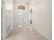 Inviting foyer with tile flooring, a transom window, and a view into the home at 9723 Pecky Cypress Way, Orlando, FL 32836