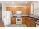 Fully-equipped kitchen with wooden cabinetry, white appliances, and ample counter space for cooking and storage at 9723 Pecky Cypress Way, Orlando, FL 32836