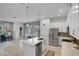 Open-concept kitchen boasts stainless appliances, white cabinetry, and a quartz island with sink at 1010 Lychee Ct, Lake Mary, FL 32746