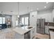 Open-concept kitchen boasts stainless appliances, white cabinetry, and a quartz island with sink at 1010 Lychee Ct, Lake Mary, FL 32746