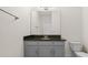 Bathroom featuring gray cabinets, black granite counters, and a big mirror at 10133 Merrymeeting Bay Dr, Winter Garden, FL 34787