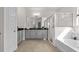 Lavish bathroom with a walk-in shower, soaking tub, and double vanities for a spa-like experience at 10133 Merrymeeting Bay Dr, Winter Garden, FL 34787