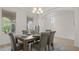 Elegant dining room with a modern chandelier, large windows, and seating for six at 10133 Merrymeeting Bay Dr, Winter Garden, FL 34787