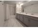 Bathroom with gray cabinets, double sinks, and shower tub at 1036 Leader Street, Davenport, FL 33896