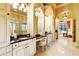 Bright bathroom with double vanity, elegant mirrors, black countertops and a marble tiled floor at 11055 Ullswater Ln, Windermere, FL 34786